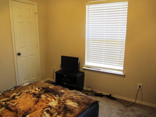 6514 89th Street Lubbock, TX 79424 - Photo 8 of 10 a bedroom with a bed and a window