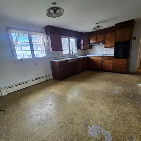 a kitchen with stainless steel appliances granite countertop a sink a stove and a refrigerator