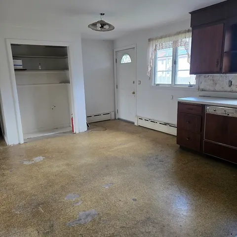 an empty room with windows and cabinet