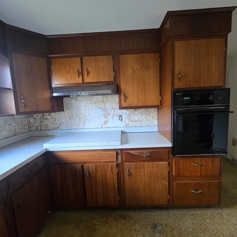 a kitchen with wooden cabinets and a stove top oven