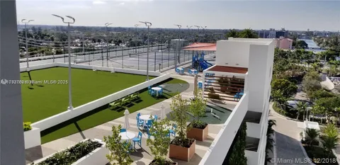 a view of a backyard with lawn chairs under an umbrella