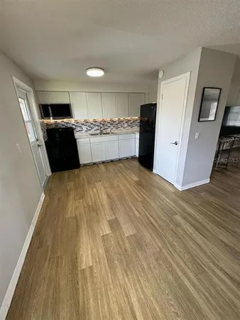 a view of kitchen with refrigerator sink and cabinets