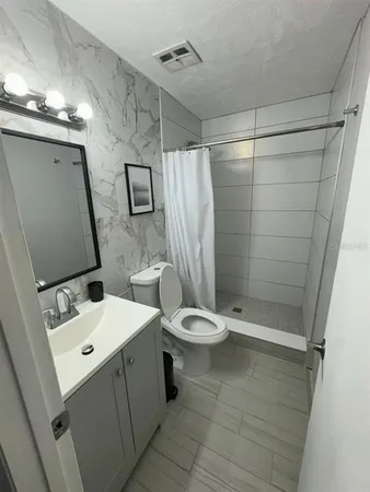 a bathroom with a toilet sink and shower