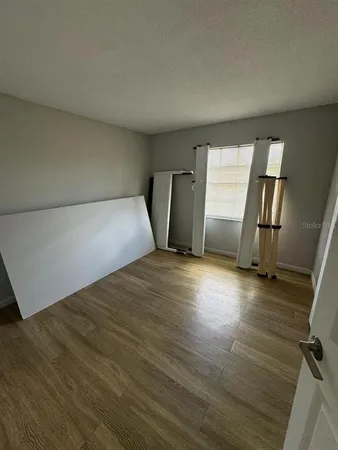 a view of empty room with wooden floor
