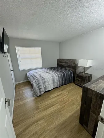 a bedroom with a bed and wooden floor