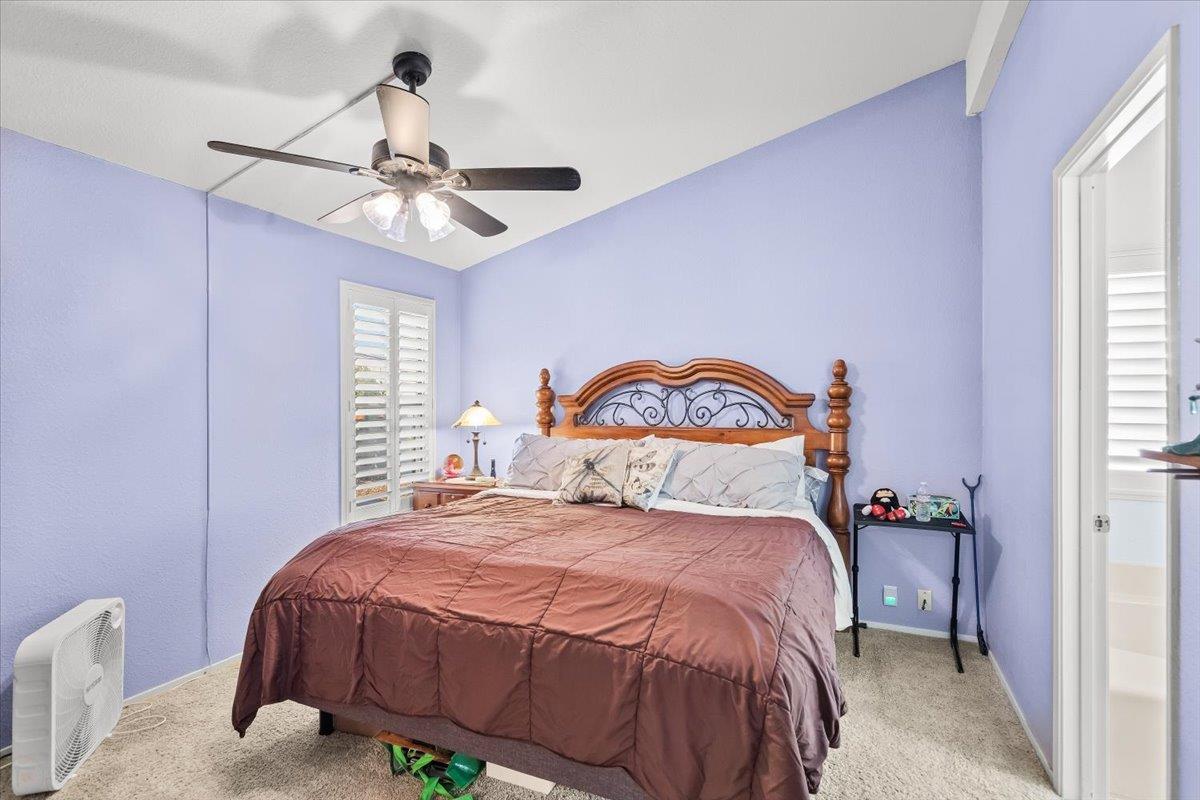 1500 Held Drive, Unit 100 Modesto, CA 95355 - Photo 29 of 59 a bedroom with a bed and a chandelier