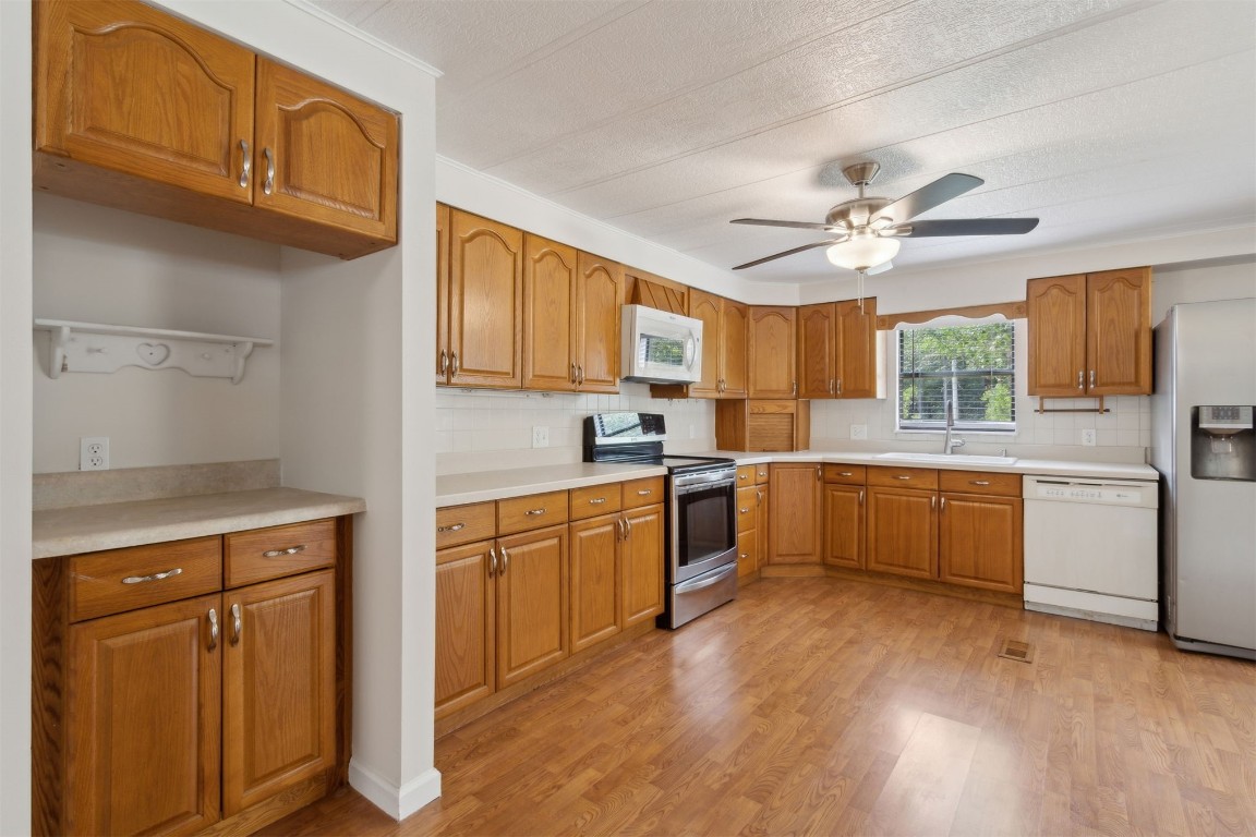 2889 Santa Fe Trail Hilliard, FL 32046 - Photo 14 of 49 a large kitchen with stainless steel appliances granite countertop a stove a sink dishwasher and a refrigerator with wooden floor