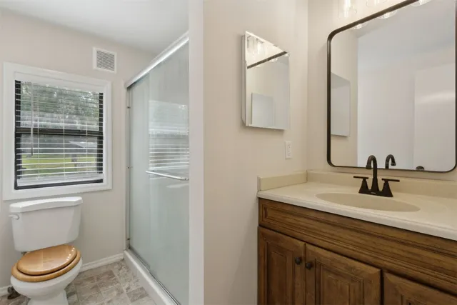 a bathroom with a granite countertop toilet sink and mirror