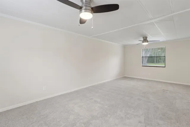 en empty room with windows and ceiling fan