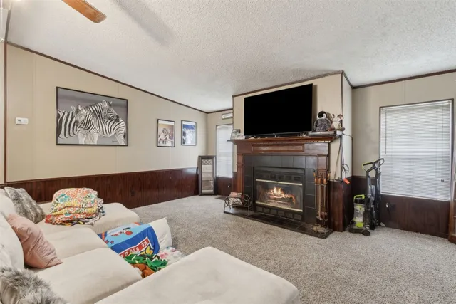 a living room with furniture a flat screen tv and a fireplace