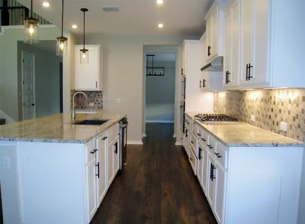 a kitchen with granite countertop a sink and a refrigerator