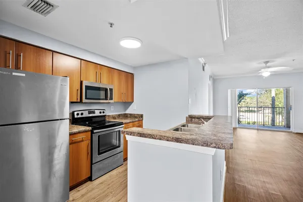 a kitchen with stainless steel appliances granite countertop a refrigerator stove microwave and sink