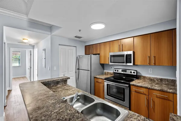 a kitchen with stainless steel appliances granite countertop a stove a sink dishwasher a refrigerator and a microwave