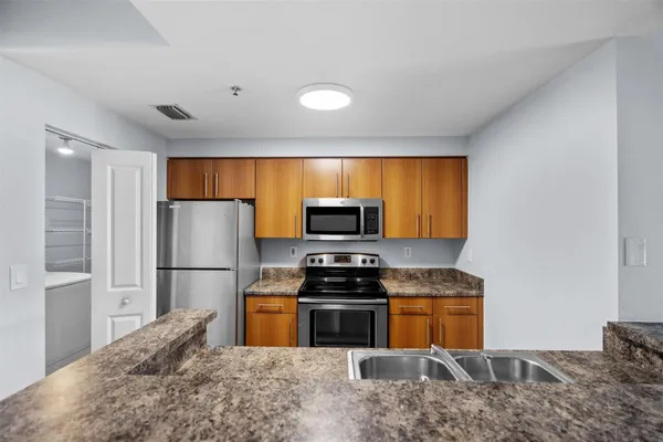 a kitchen with a refrigerator and a stove top oven