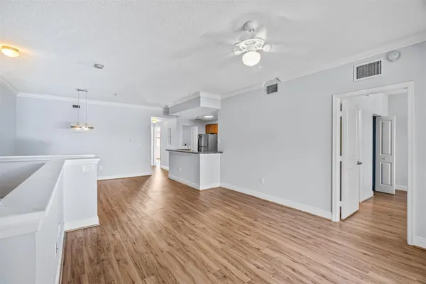 a view of empty room with wooden floor