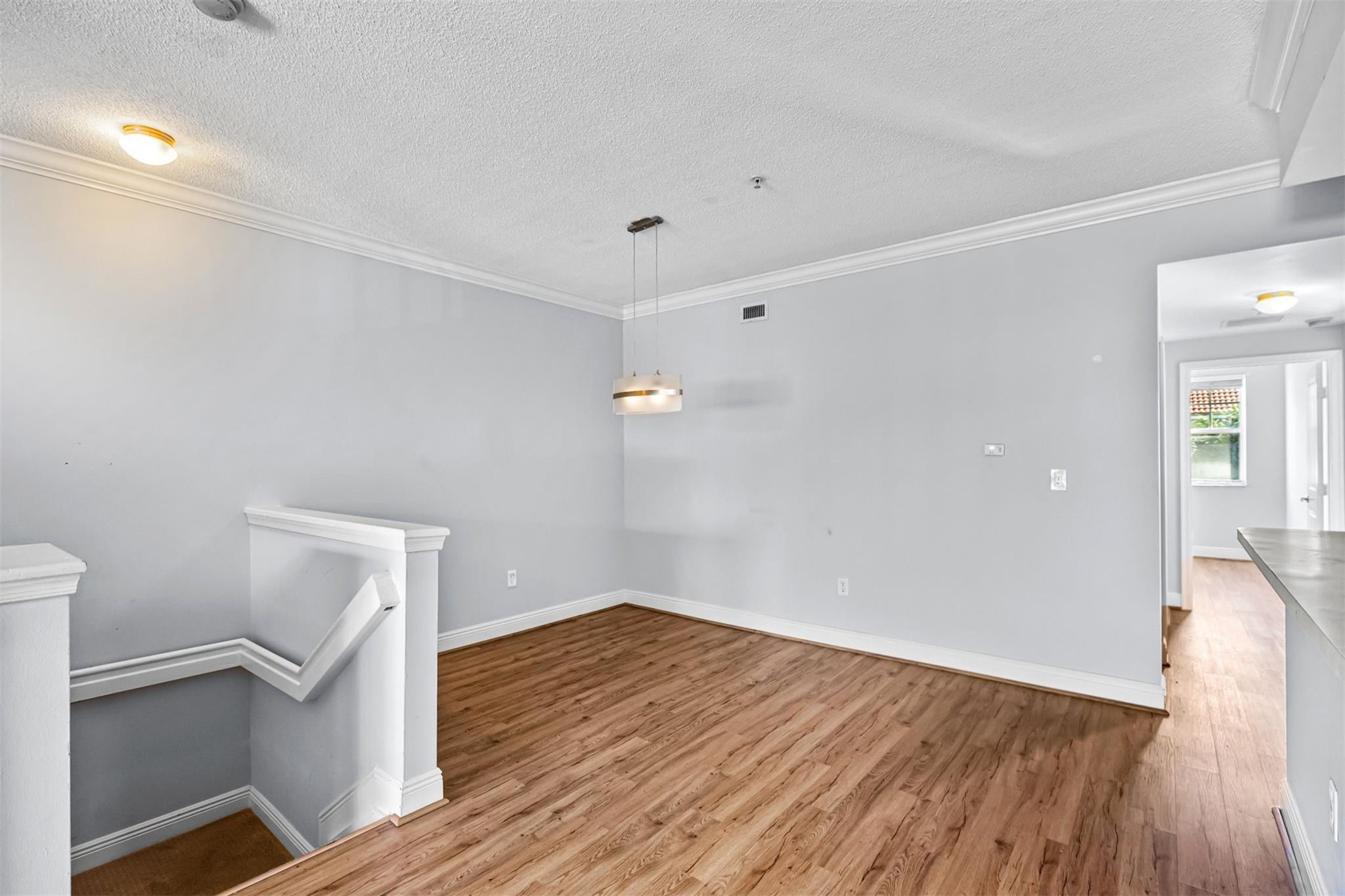 5880 West Sample Road, Unit 307 Coral Springs, FL 33067 - Photo 6 of 25 a view of an empty room with wooden floor and a window