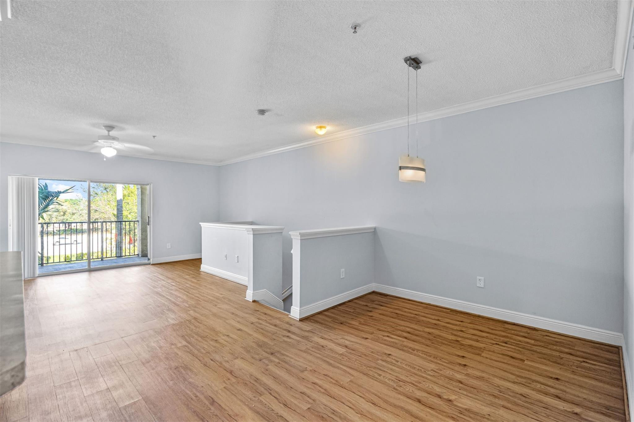 5880 West Sample Road, Unit 307 Coral Springs, FL 33067 - Photo 9 of 25 wooden floor in an empty room with a window