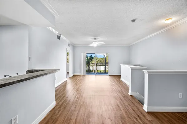 a view of entryway with kitchen and wooden floor