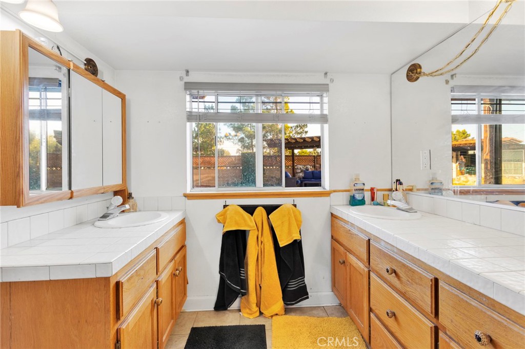 14415 Erie Road Apple Valley, CA 92307 - Photo 40 of 61 a bathroom with a granite countertop sink and a large mirror