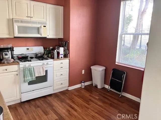 a kitchen with a stove a sink and wooden floor