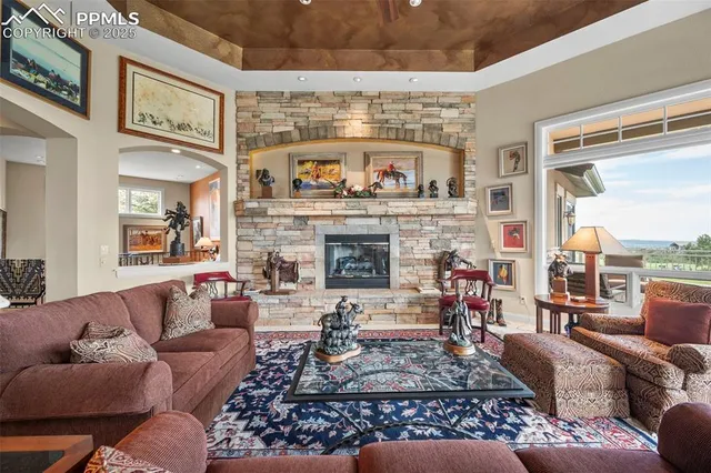 a living room with furniture large window and a fireplace