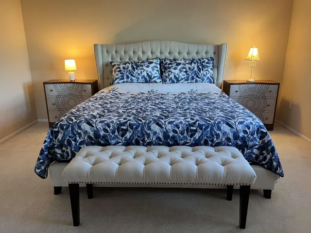 a bed sitting in a bedroom next to a lamp