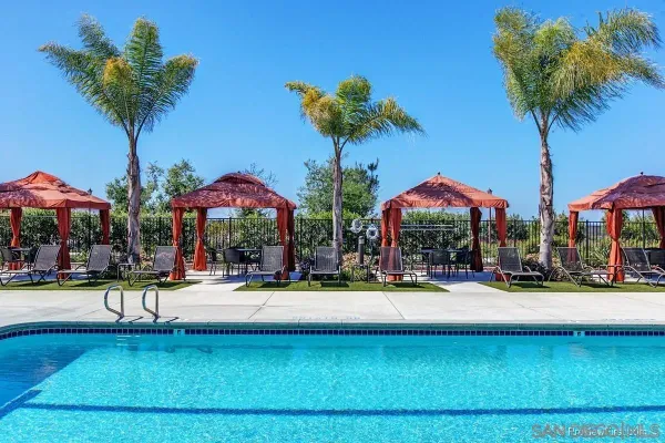 a view of swimming pool with table and chairs under an umbrella