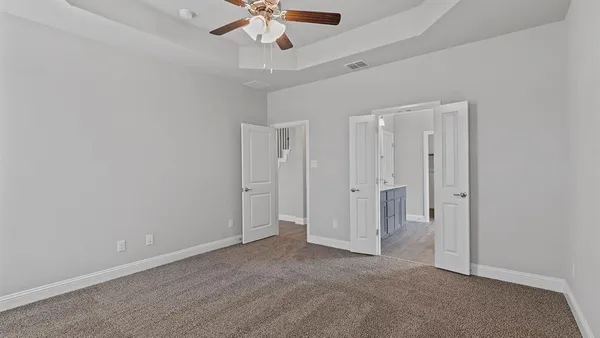 an empty room with a window and a fan