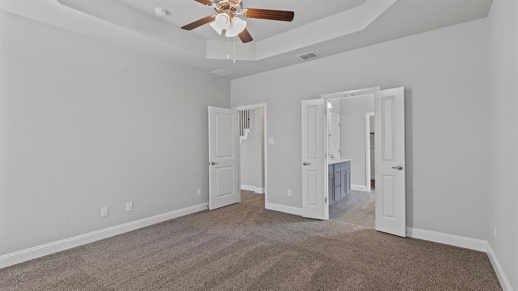 729 Soaring Hawk Drive Aledo, TX 76008 - Photo 13 of 38 an empty room with a chandelier fan and windows