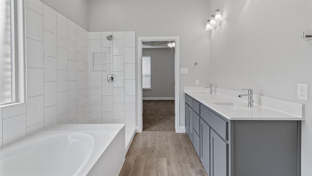 729 Soaring Hawk Drive Aledo, TX 76008 - Photo 15 of 38 a bathroom with a double vanity sink a mirror and a bathtub