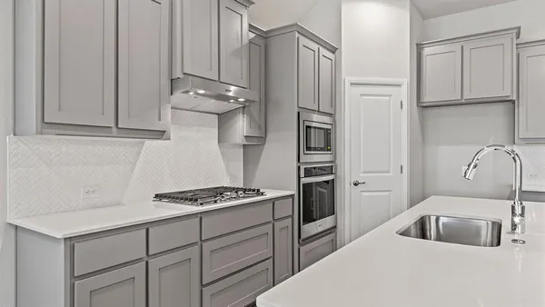 a kitchen with kitchen island white cabinets and stainless steel appliances