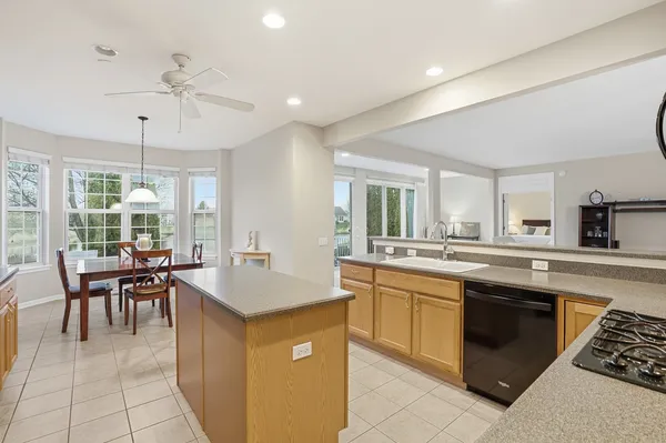 a kitchen with center island white cabinets and stainless steel appliances