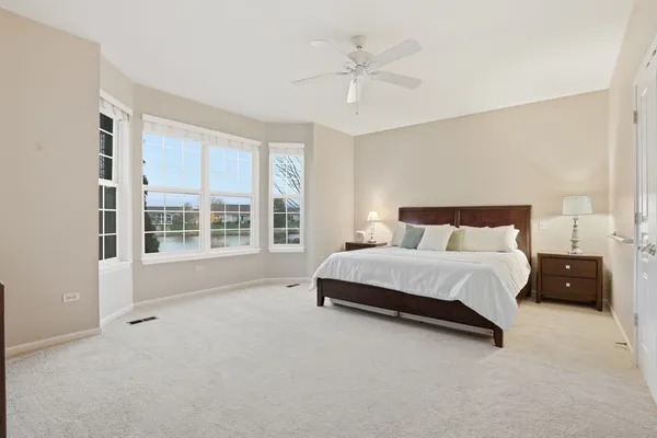 a spacious bedroom with a bed and a large window