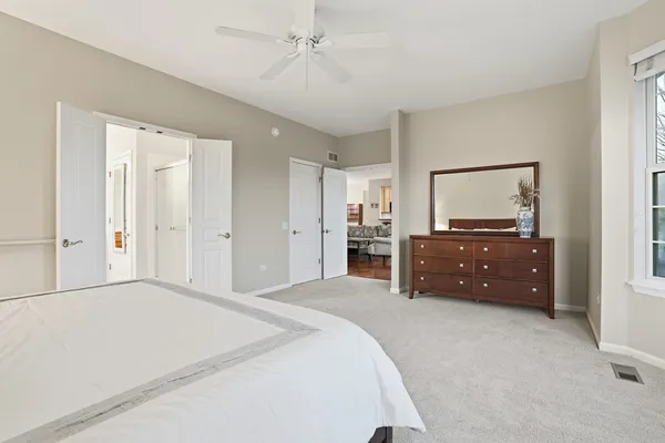 a spacious bedroom with a bed and a flat screen tv