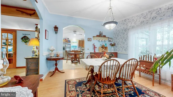a kitchen with stainless steel appliances kitchen island granite countertop a table chairs sink and cabinets