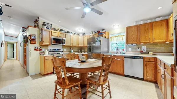 a dining room with kitchen island stainless steel appliances kitchen island granite countertop a refrigerator and a stove top oven