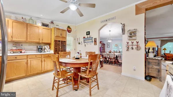 a kitchen with a refrigerator a stove a sink dishwasher and a dining table with wooden floor