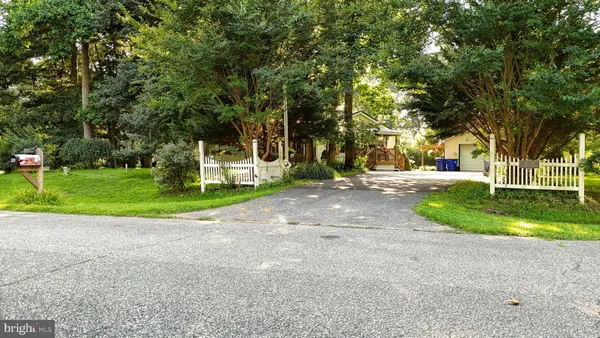 a view of a house with a big yard and palm trees
