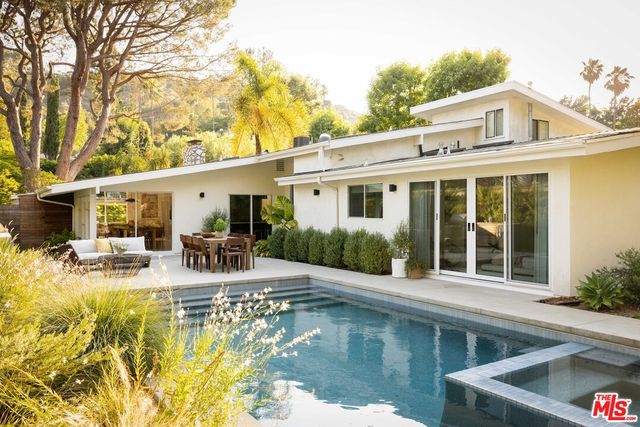 a view of house with swimming pool outdoor seating