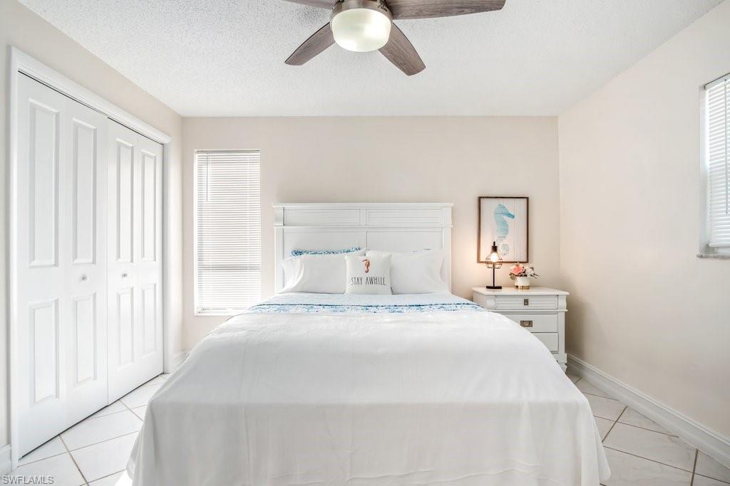 1207 Hernando Street Naples, FL 34103 - Photo 22 of 37 a bedroom with a bed and a chandelier