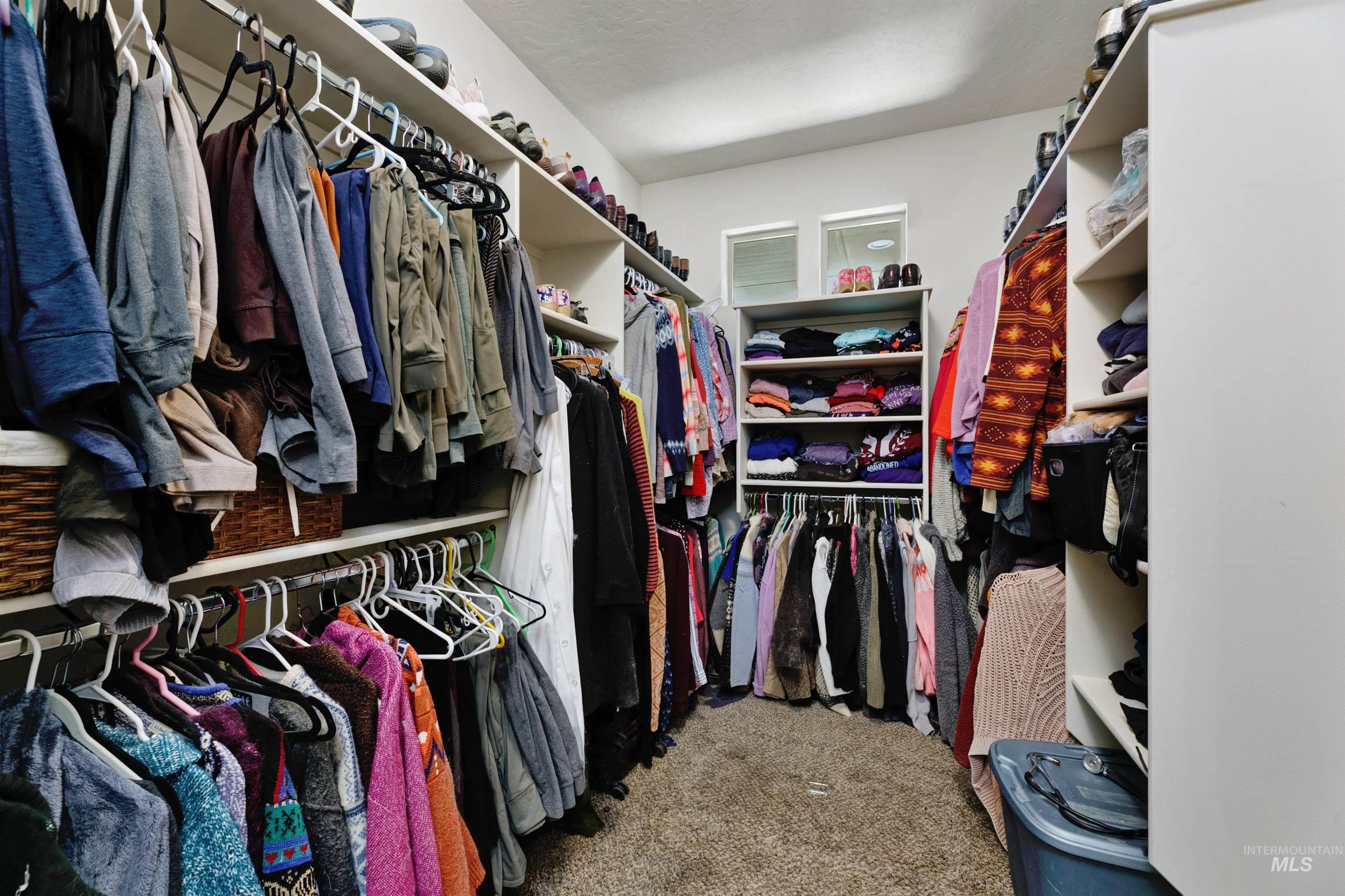 24398 Tombstone Ridge Court Middleton, ID 83644 - Photo 11 of 47 Carpeted closet with extensive built-in shelving, multiple hanging rods, and recessed windows
