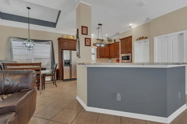 a kitchen with stainless steel appliances kitchen island granite countertop a refrigerator a stove and a sink