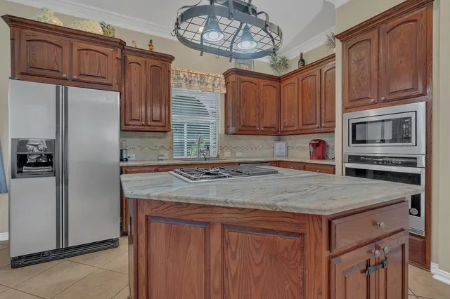 a kitchen with stainless steel appliances granite countertop a sink refrigerator stove and microwave