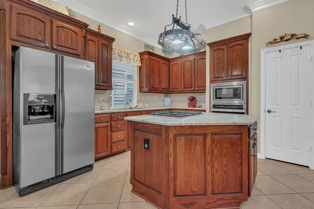 a kitchen with stainless steel appliances granite countertop a refrigerator and a stove