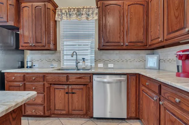 a kitchen with stainless steel appliances granite countertop wooden cabinets a sink and dishwasher