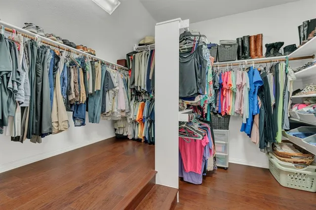 a view of walk in closet with clothes and shoes