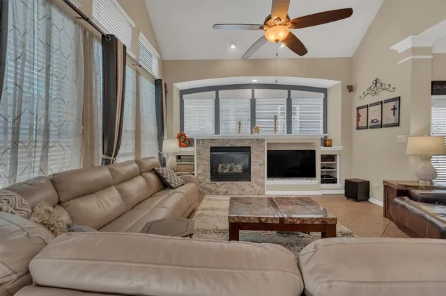 a living room with furniture ceiling fan and a fireplace