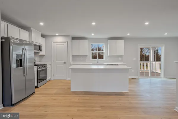 a large kitchen with kitchen island a sink a center island stainless steel appliances and a cabinets