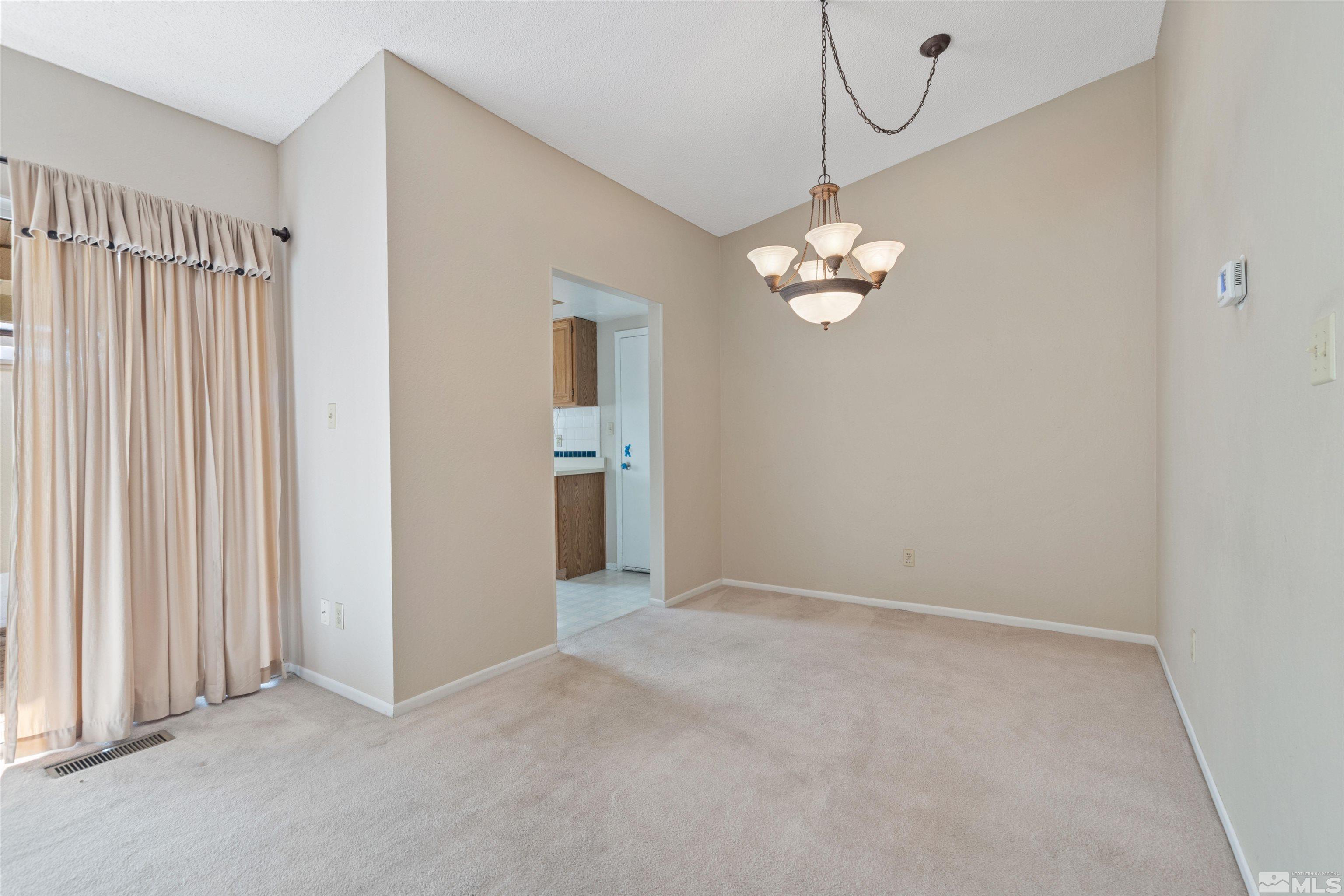 1236 Laredo Court Reno, NV 89503 - Photo 7 of 29 an empty room with chandelier closet and windows