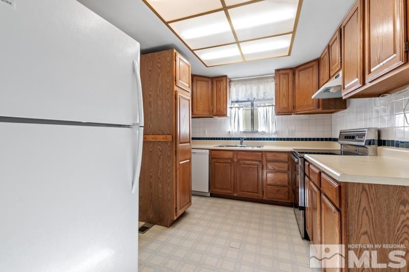 1236 Laredo Court Reno, NV 89503 - Photo 8 of 29 a kitchen with a sink a refrigerator and cabinets